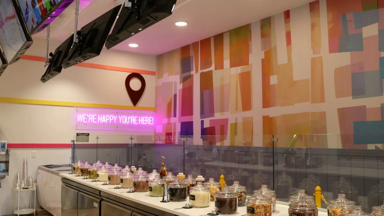 The toppings bar of glass jars leading to our pink neon sign, We're happy you're here